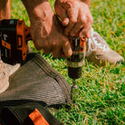 Ground Puppies Screw in Peg being screwed into a caravan mat close up