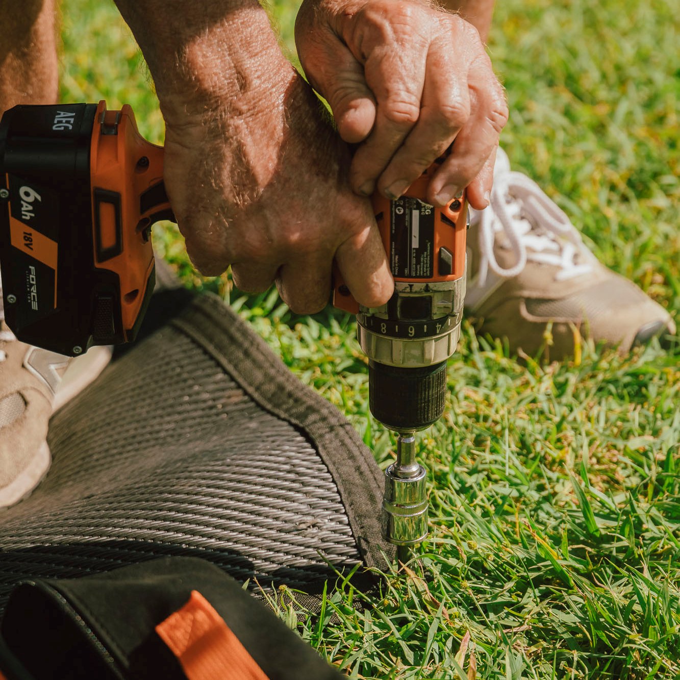 Ground Puppies Screw in Peg being screwed into a caravan mat close up